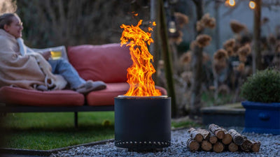 Vatra RedFire Volcano Large aprinsa intr-o gradina, seara